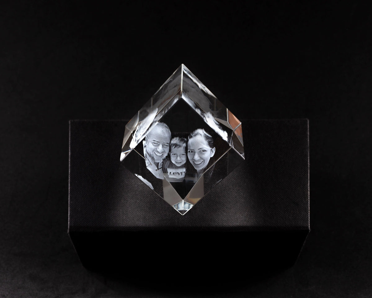 Rombo de cristal 3D con la foto de una pareja grabada, sobre fondo negro