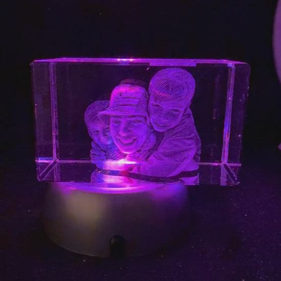 Vídeo del prisma panorámico Imperial de cristal 3D con un hombre y dos niños grabados, girando sobre la base LED que cambia de color